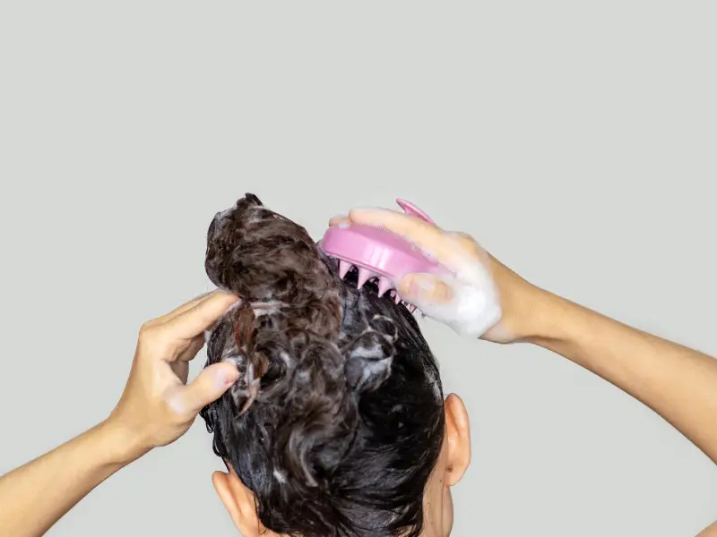 a woman exfoliating her scalp