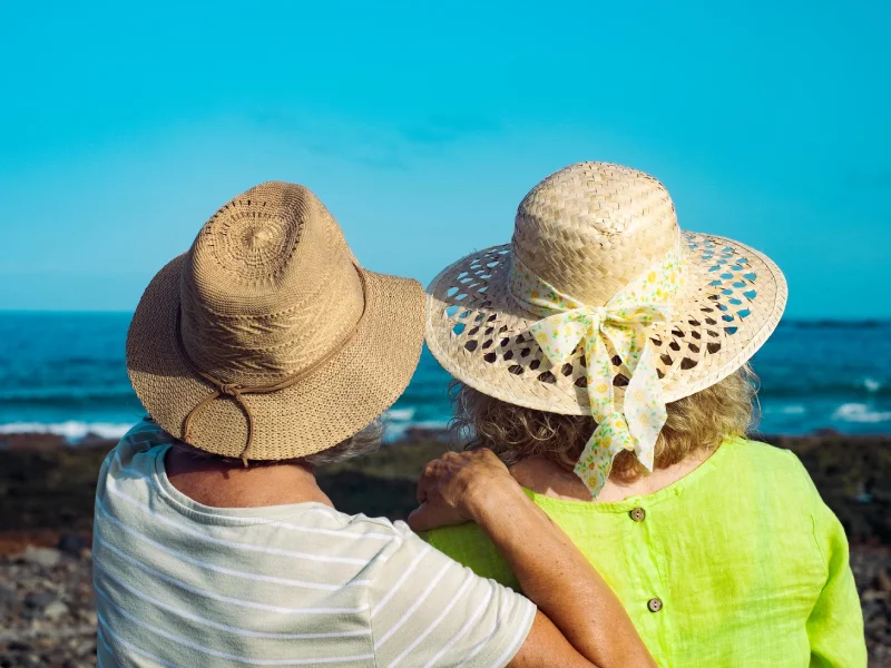 a couple of a man and woman wearing hats at the beach